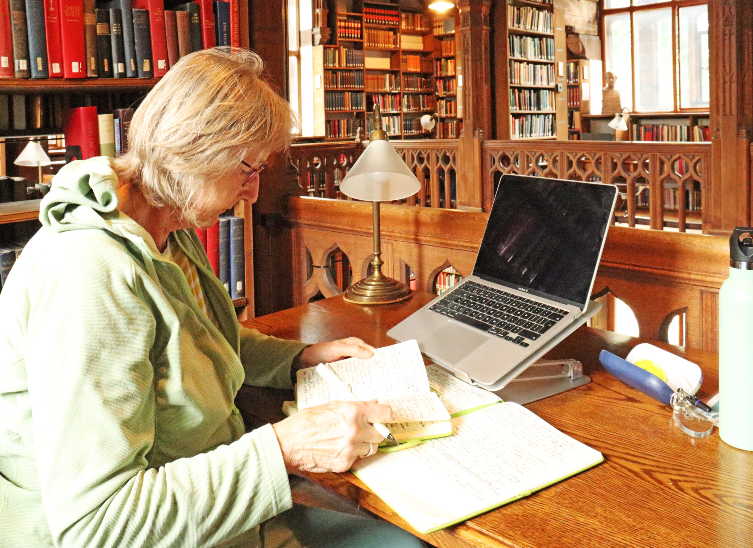 Author Karen Lloyd working at a desk in the Theology Room